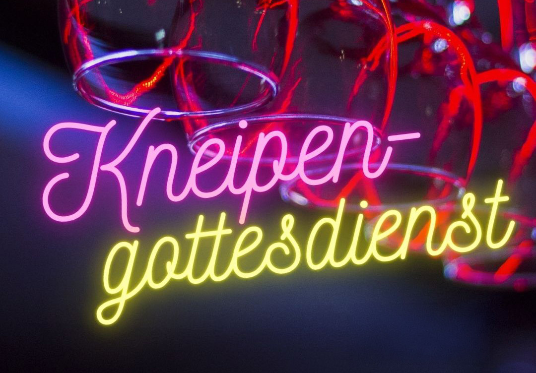 Text "Kneipengottesdienst" in geschwungener rosa-gelben Neonschrift vor auf dem Kopf hängenden Weingläsern.