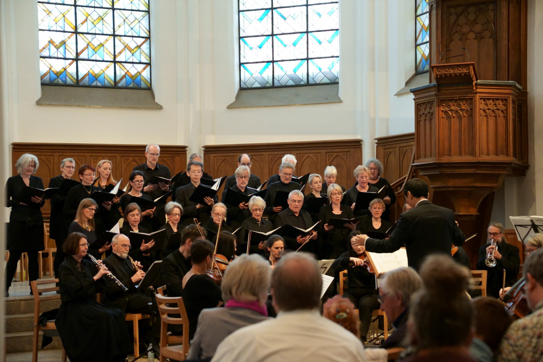 Die Kantorei der Ev. Stadtkirche Moers, schwarz gekleidet im Altarraum der Stadtkirche während ihrer Darbietung.