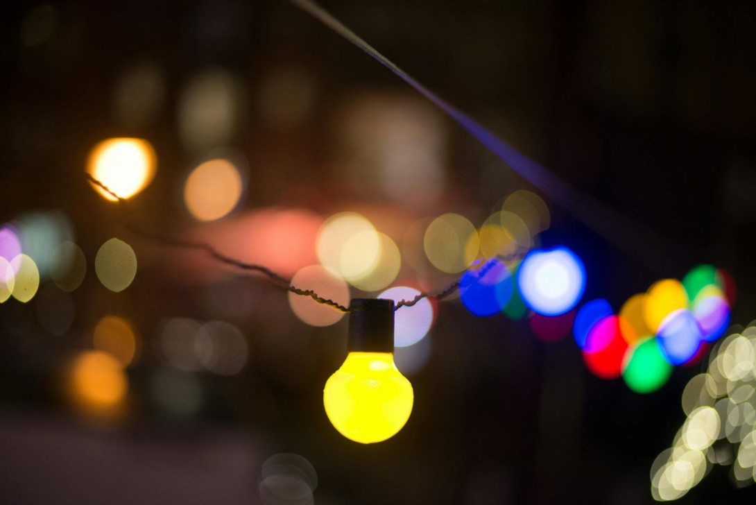 Eine bunte Lichterkette in der Dunkelheit.